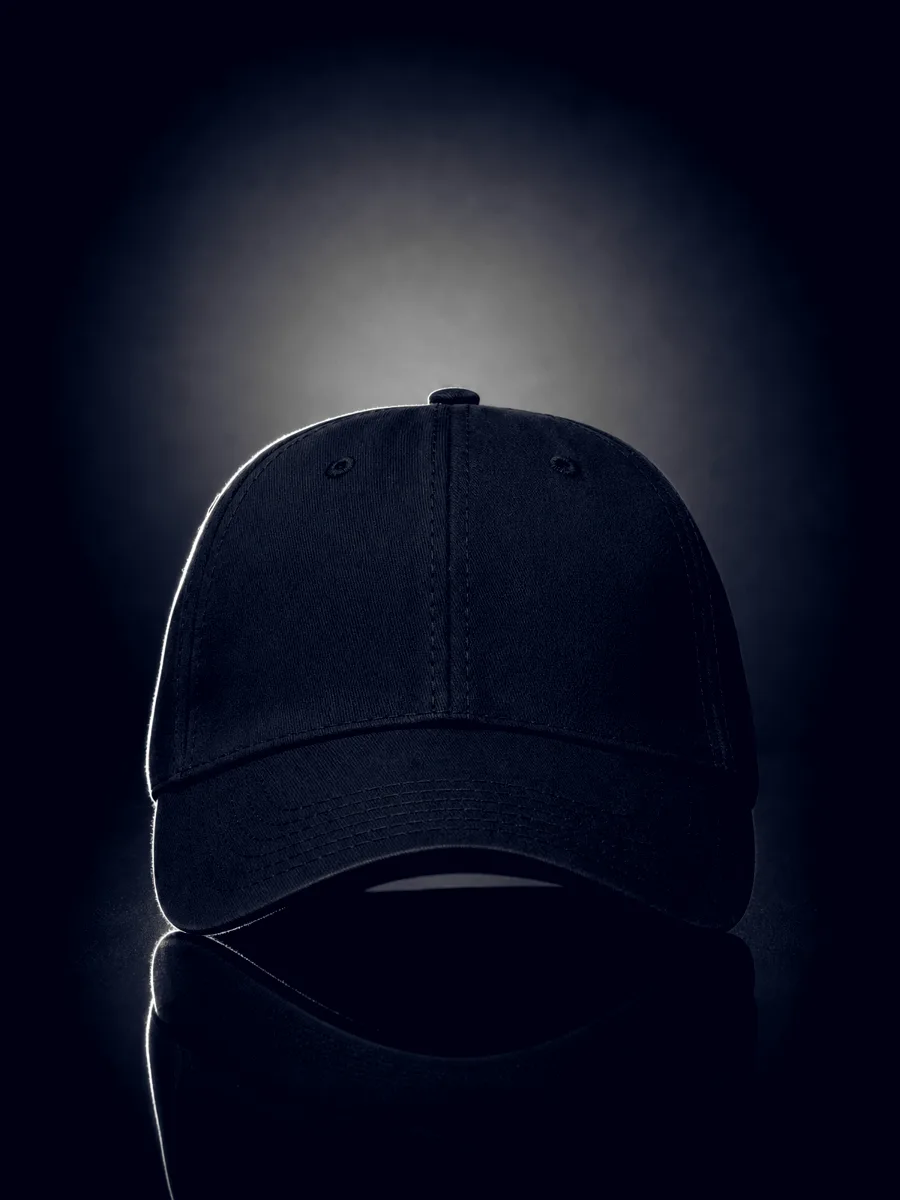 Black six-panel BirdHaus cap on a reflective surface